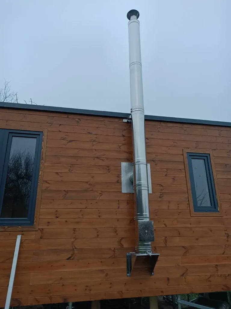 Dokončený nerezový trojplášťový komín na drevenom dome